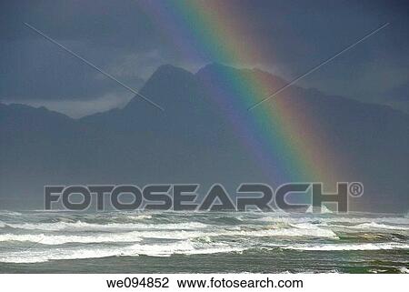 Stock Image - Rainbow on Ocean by cloudy day, Hermanus, South Western Cape, South Africa. Fotosearch
