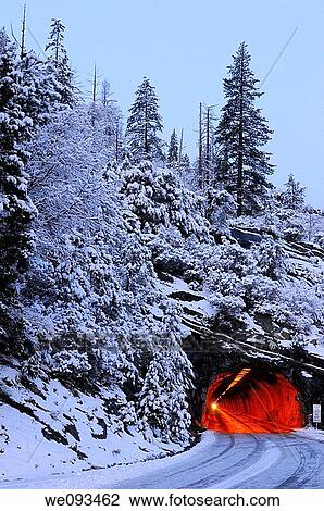 Stock Image - Red Wawona Road tunnel and blue snow covered mountain at dawn in Yosemite National Park. Fotosearch