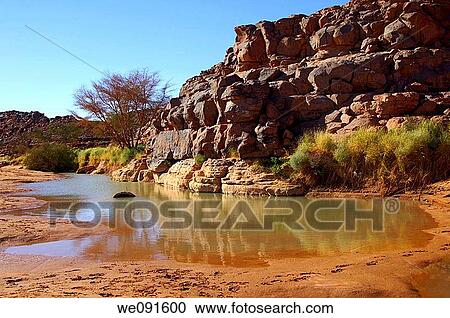 Remaining water in a riverbed near the prehistoric archeological sites in Wadi Mathendous, Mesak Settafet plateau, Libya View Large Photo Image Stock Image - Remaining water in a riverbed near the prehistoric archeological sites in Wadi Mathendous, Mesak Settafet plateau, Libya. Fotosearch