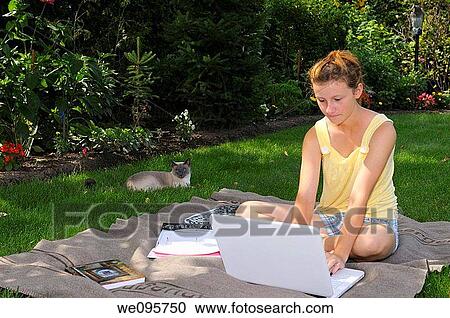 Siamaese cat lounging with teenager typing on laptop in back yard shade View Large Photo Image Stock Image - Siamaese cat lounging with teenager typing on laptop in back yard shade. Fotosearch