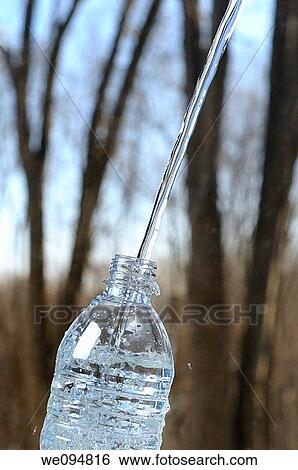 Smooth stream of pure water filling up a clear plastic bottle outdoors in the bush View Large Photo Image Stock Photograph - Smooth stream of pure water filling up a clear plastic bottle outdoors in the bush. Fotosearch
