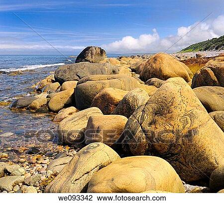Stock Image - Smoothed rust colored boulders on the shore of Martins Point where SS Ethie sank in 1919. Fotosearch