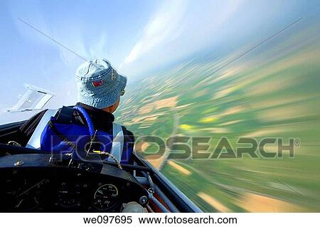 soaring in the sky with landscape rushing below, pilot and instruments in foreground View Large Photo Image Stock Photography - soaring in the sky with landscape rushing below, pilot and instruments in foreground. Fotosearch