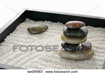 Stacked polished rocks in a miniature Zen rock garden sandbox View Large Photo Image Stock Image - Stacked polished rocks in a miniature Zen rock garden sandbox. Fotosearch