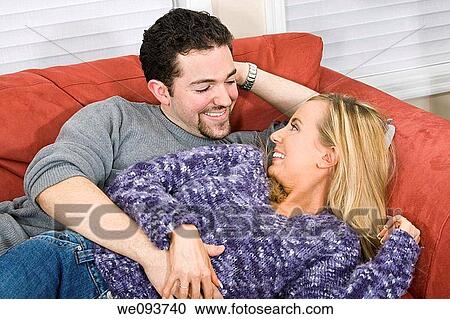 Studio photograph of young Caucasian couple posing with their arms around each other on a white background View Large Photo Image Stock Image - Studio photograph of young Caucasian couple posing with their arms around each other on a white background. Fotosearch