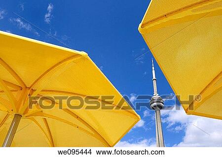 Toronto CN tower between two yellow metal beach umbrellas at urban beach of HTO Park View Large Photo Image Picture - Toronto CN tower between two yellow metal beach umbrellas at urban beach of HTO Park. Fotosearch