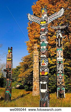 Totem polies in Stanley Park Vancouver with raven and changing maple leaves in Autumn on blue sky View Large Photo Image Picture - Totem polies in Stanley Park Vancouver with raven and changing maple leaves in Autumn on blue sky. Fotosearch