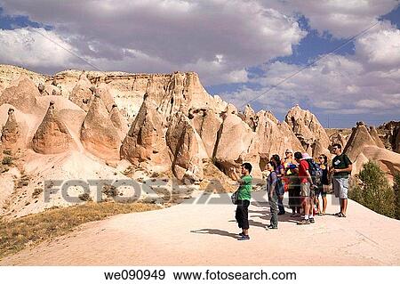 Stock Photo - Tourists visiting the pedestal and cone shaped eroded rock formations hardened volcanic ash in the Camel valley, Cappadocia region, Turkey. Fotosearch