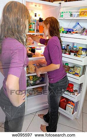 Stock Photo - Transparent conscience of young teenage girl concerned about snack choices at the refrigerator. Fotosearch