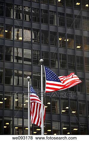 Two American Flags in front of a black glass building View Large Photo Image Stock Photo - Two American Flags in front of a black glass building. Fotosearch