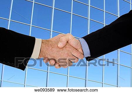 Two caucasian businessman in a black business suits shaking hands to close a deal They are shown in front of an office building View Large Photo Image Stock Photo - Two caucasian businessman in a black business suits shaking hands to close a deal They are shown in front of an office building. Fotosearch