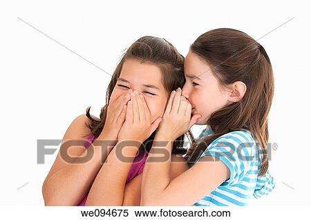 Two Caucasian girls telling secrets on white background View Large Photo Image Stock Photography - Two Caucasian girls telling secrets on white background. Fotosearch
