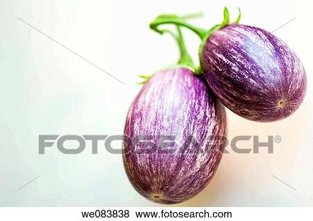 Stock Photo - Two Freshly Harvested Graffiti Eggplants on Cutting Board. Solanum melongena.. Fotosearch