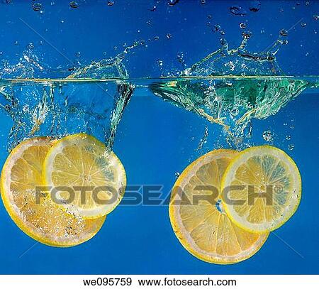Two pairs of lemon and grapefruit slices splashing into water with a blue background View Large Photo Image Stock Photo - Two pairs of lemon and grapefruit slices splashing into water with a blue background. Fotosearch