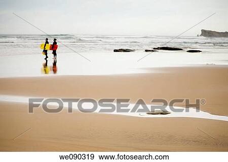 two surfers on a beach. Liencres beach. Cantabria, Spain, Europe View Large Photo Image Stock Photo - two surfers on a beach. Liencres beach. Cantabria, Spain, Europe. Fotosearch