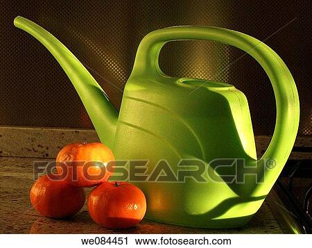 Stock Image - Watering can and tangerines. Fotosearch