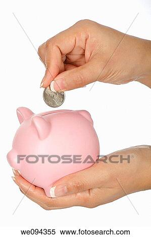 Stock Photography - Woman holding a piggy bank and placing a quarter into it. Fotosearch