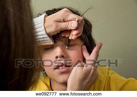 Woman putting theatrical makeup on a boy's face View Large Photo Image Stock Photo - Woman putting theatrical makeup on a boy's face. Fotosearch