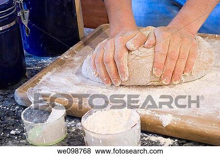 Woman's hands kneading some whole wheat bread dough on a wooden cutting board, with flour on the board and in measuring cups View Large Photo Image Stock Photo - Woman's hands kneading some whole wheat bread dough on a wooden cutting board, with flour on the board and in measuring cups. Fotosearch