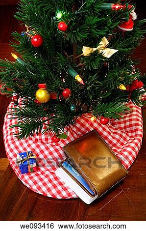 Worn leather wallet with charge cards and check under the decorated Christmas tree View Large Photo Image Stock Photograph - Worn leather wallet with charge cards and check under the decorated Christmas tree. Fotosearch
