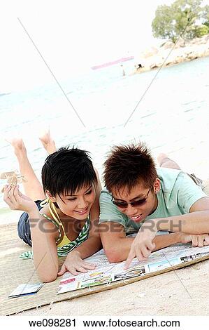 Young asian couple looking at map View Large Photo Image Stock Image - Young asian couple looking at map. Fotosearch