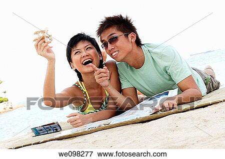 Stock Photo - Young asian couple with girl holding a toy airplane. Fotosearch