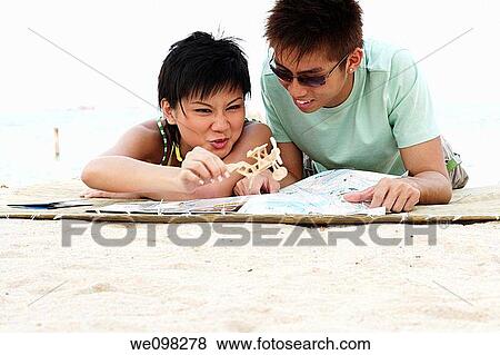 Stock Photo - Young asian couple with girl holding a toy airplane. Fotosearch