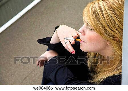 Young blond woman smoking a cigarette View Large Photo Image Stock Photography - Young blond woman smoking a cigarette. Fotosearch