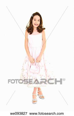 Stock Photo - Young caucasian girl dressed in a Easter dress and standing on a white background. Fotosearch
