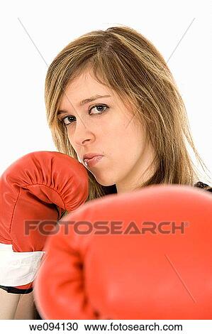 Stock Image - Young Caucasian teenager in red boxing gloves getting ready to fight. Fotosearch