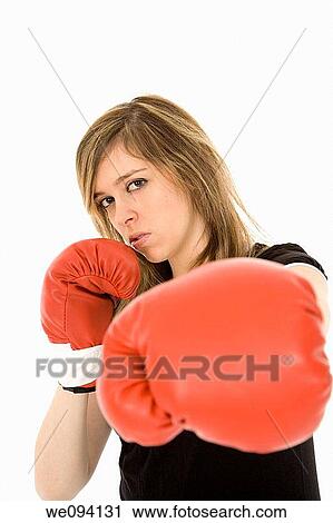 Stock Image - Young Caucasian teenager in red boxing gloves getting ready to fight. Fotosearch