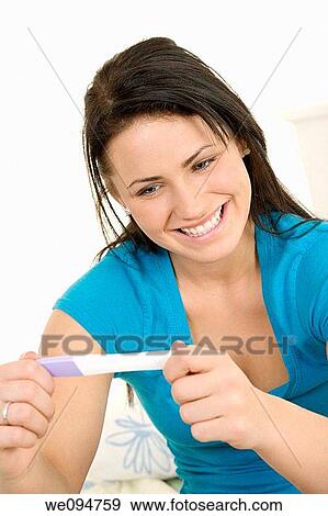 Young Caucasian woman looking at pregnancy test View Large Photo Image Stock Photo - Young Caucasian woman looking at pregnancy test. Fotosearch