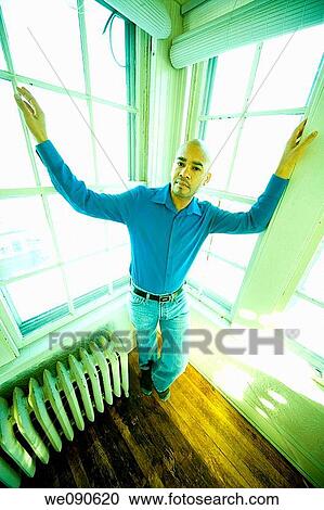 Young Hispanic man posing in front of several windows View Large Photo Image Stock Image - Young Hispanic man posing in front of several windows. Fotosearch
