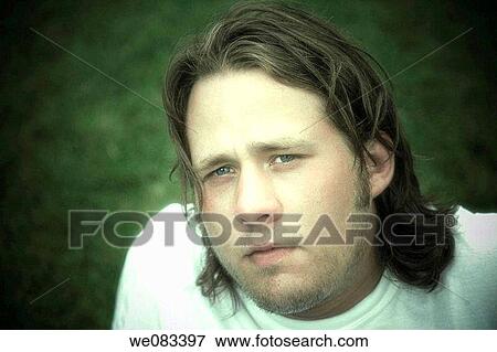 Young man posing on the grass at a park. View Large Photo Image Stock Photo - Young man posing on the grass at a park.. Fotosearch