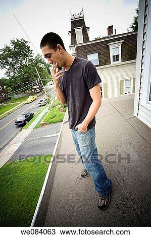 Young man standing on the roof of his house View Large Photo Image Stock Image - Young man standing on the roof of his house. Fotosearch