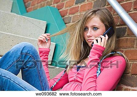 Young teenage girl talking on cell phone outside of a school building View Large Photo Image Stock Image - Young teenage girl talking on cell phone outside of a school building. Fotosearch