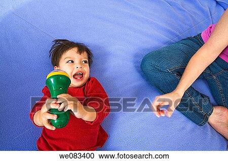 Young white woman sitting next to her toddler Eurasian son, who is playing with a toy. View Large Photo Image Stock Image - Young white woman sitting next to her toddler Eurasian son, who is playing with a toy.. Fotosearch