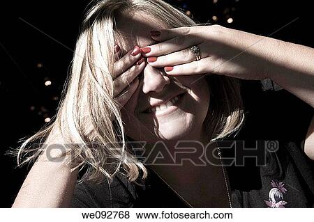 Young woman covering her eyes View Large Photo Image Stock Photo - Young woman covering her eyes. Fotosearch