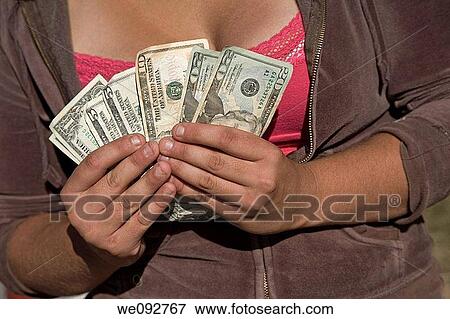 Young woman holding American money View Large Photo Image Stock Photo - Young woman holding American money. Fotosearch
