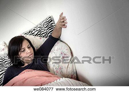 Young woman lying in bed View Large Photo Image Stock Photo - Young woman lying in bed. Fotosearch