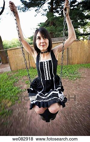 Young woman on a playground swing View Large Photo Image Stock Photo - Young woman on a playground swing. Fotosearch