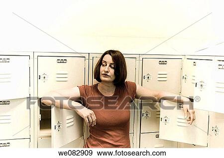 Young woman standing among a group of lockers. View Large Photo Image Stock Photo - Young woman standing among a group of lockers.. Fotosearch