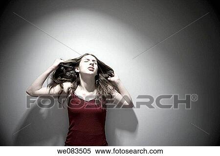 Young woman standing in front of a wall. View Large Photo Image Stock Photography - Young woman standing in front of a wall.. Fotosearch