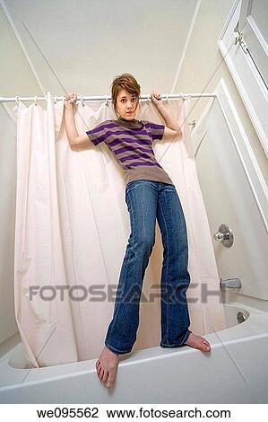Young woman standing on the side of her bathtub View Large Photo Image Stock Image - Young woman standing on the side of her bathtub. Fotosearch