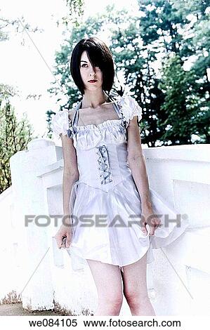 Young woman, wearing a white dress, standing on a bridge View Large Photo Image Stock Photography - Young woman, wearing a white dress, standing on a bridge. Fotosearch