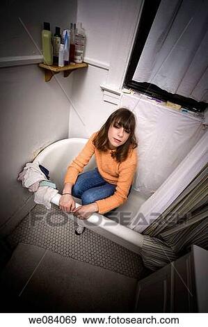 Young woman, wearing her street clothes, sitting in her bathtub View Large Photo Image Stock Photo - Young woman, wearing her street clothes, sitting in her bathtub. Fotosearch