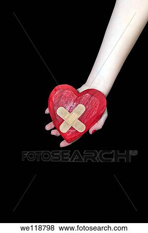 a female hand is holding a broken heart View Large Photo Image Stock Photo - a female hand is holding a broken heart. Fotosearch