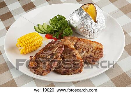 Bone in Lamb with corn and a baked potato with a clipping path View Large Photo Image Stock Image - Bone in Lamb with corn and a baked potato with a clipping path. Fotosearch