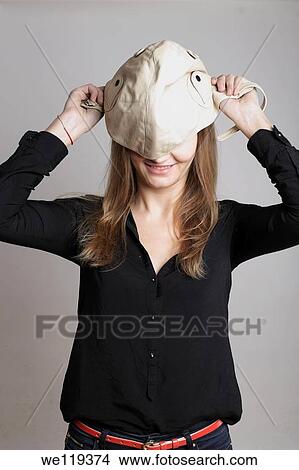 Picture - Girl trying on hat. Fotosearch