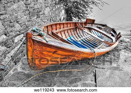 Wood boat lying on the stones View Large Photo Image Stock Image - Wood boat lying on the stones. Fotosearch